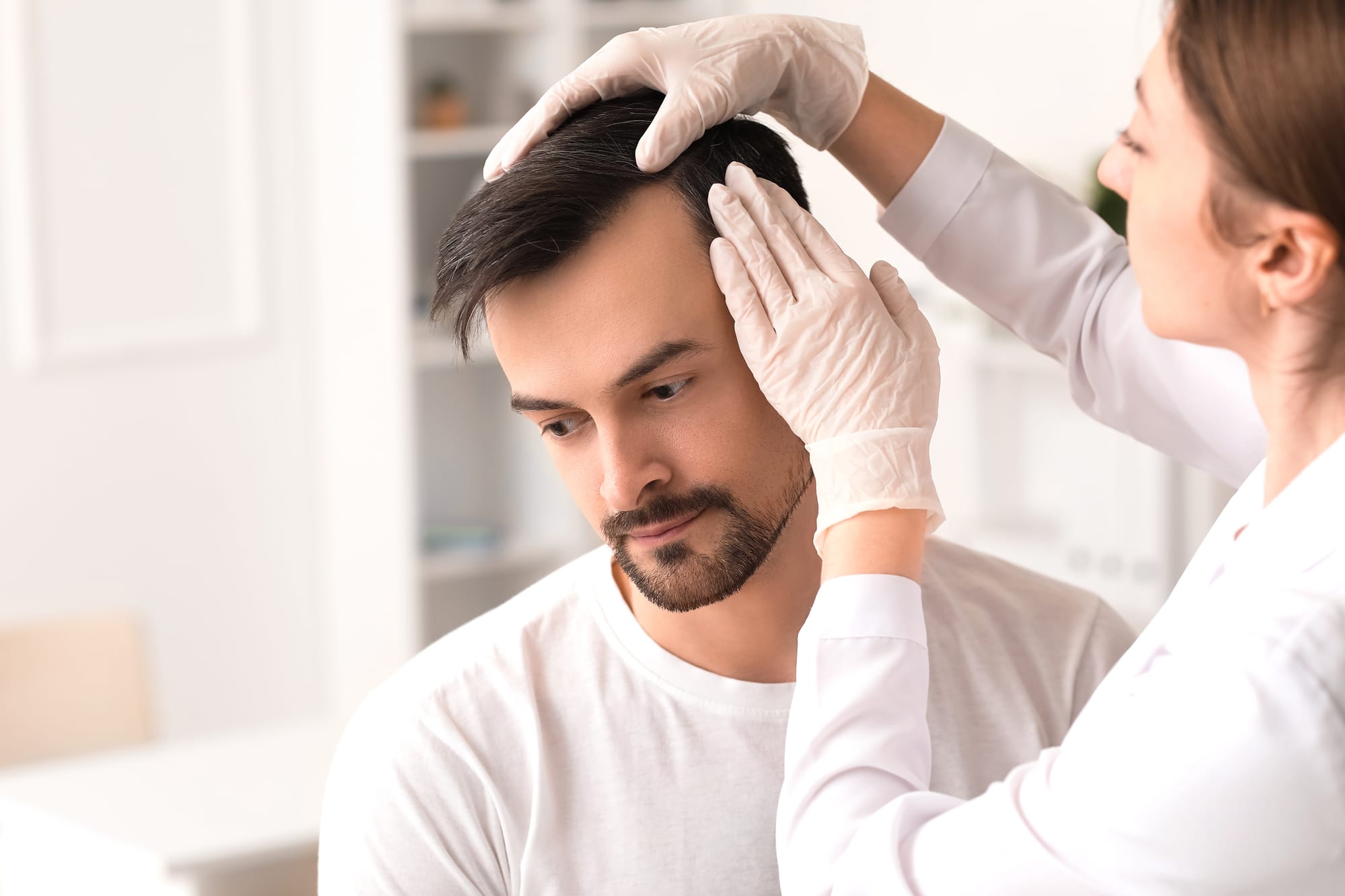 Man receiving hair restoration consultation at Menon Medispa
